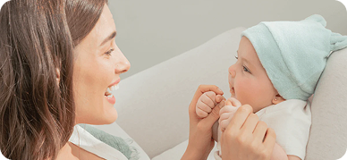 Madre sonriendo a su bebé recién nacido